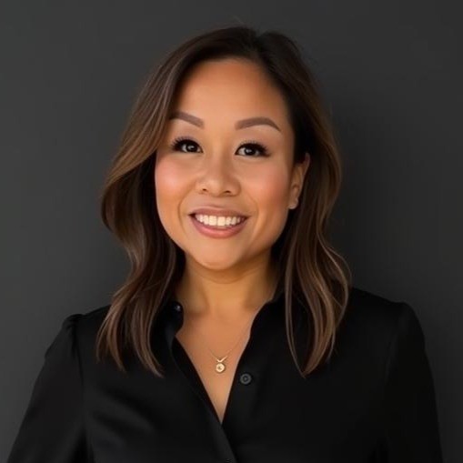 Professional headshot of a woman in black, smiling warmly against gray background